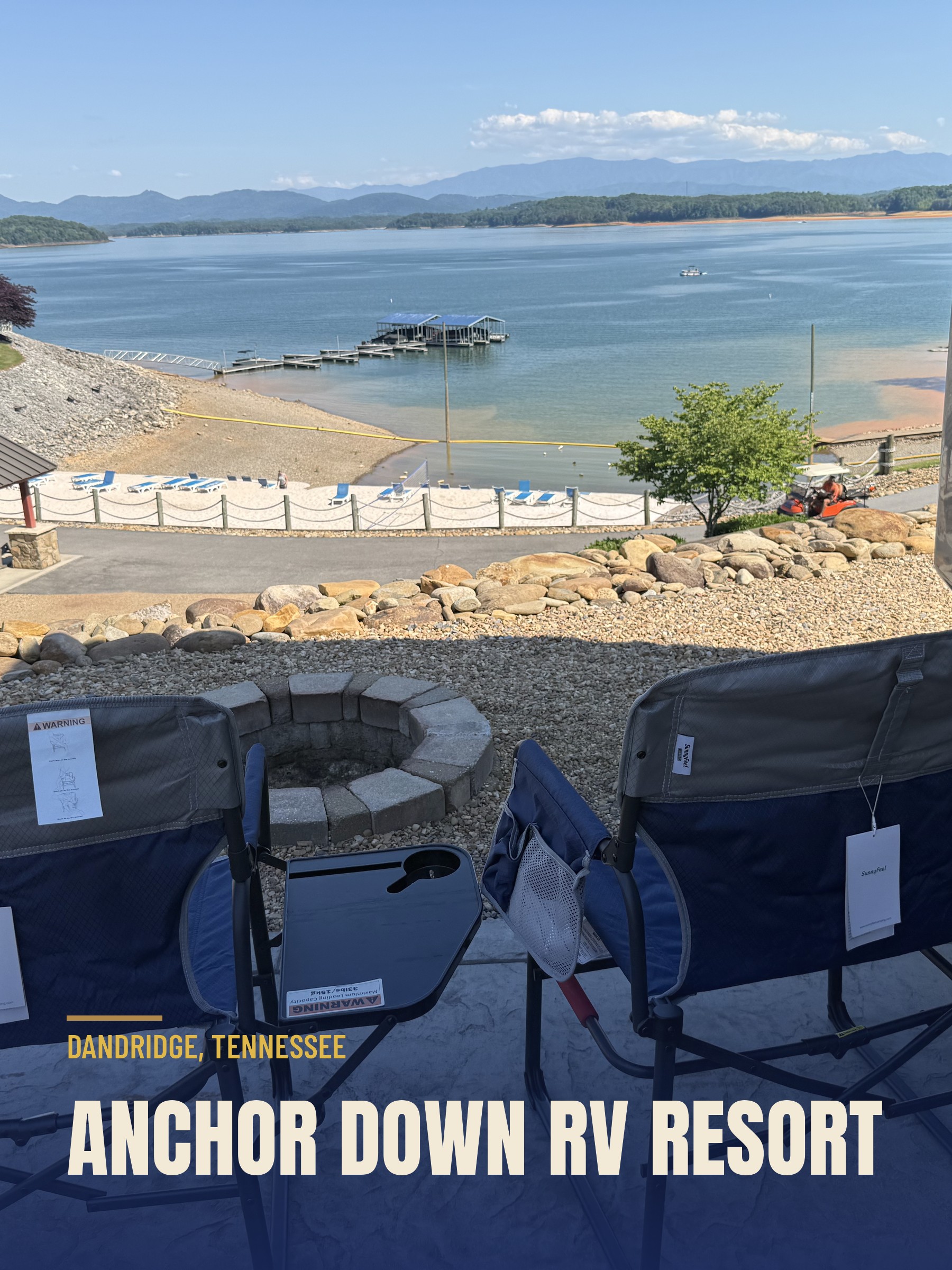 Two camp chairs and a stone firepit on a paved RV site at Anchor Down, overlooking Douglas Lake and the Smoky Mountains.