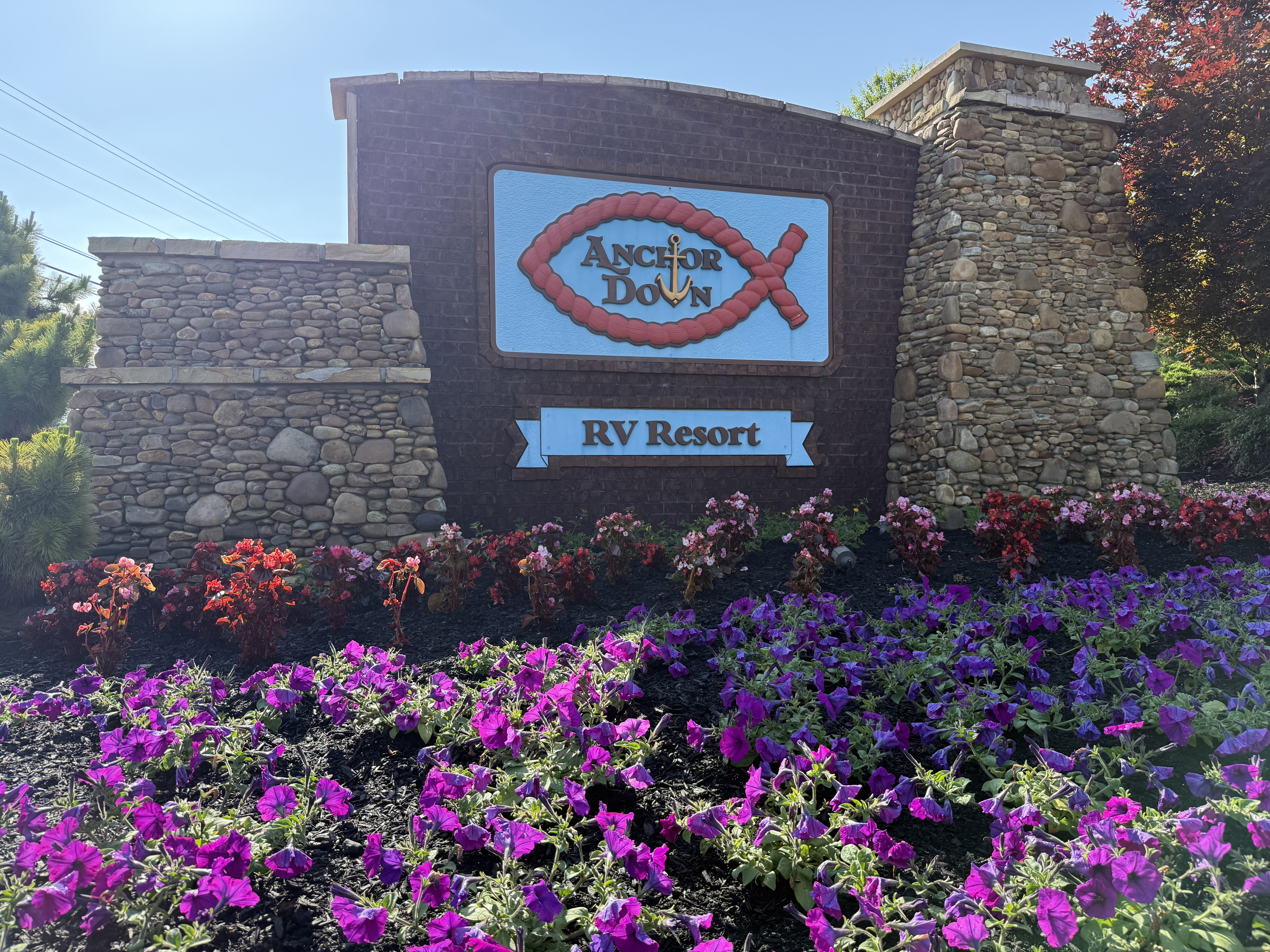 Entrance to Anchors Down RV Resort surrounded by flowers