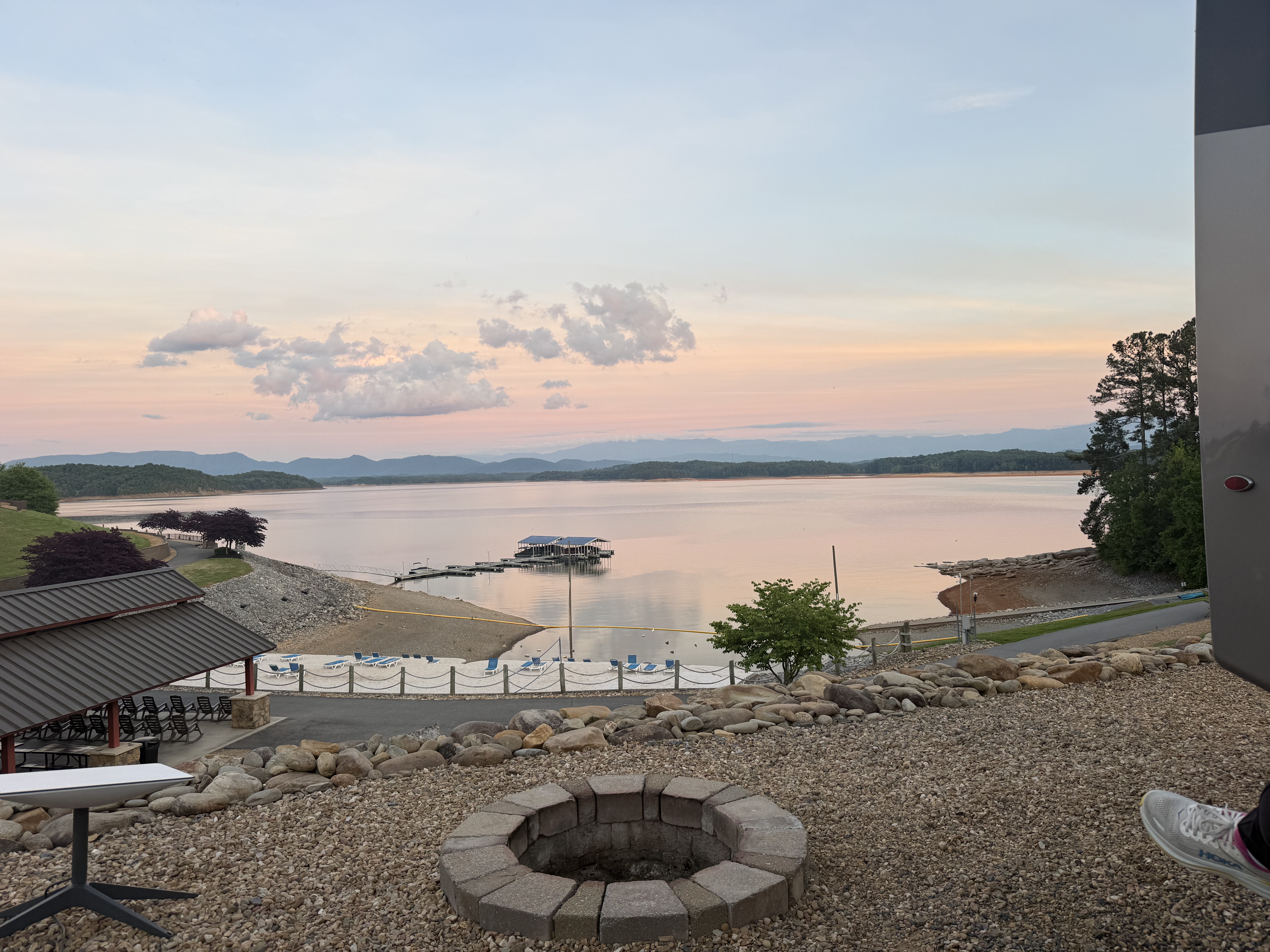 Pastel sunset over Douglas Lake at Anchor Down RV Resort, with a covered boat dock and the Smokey Mountains in the distance