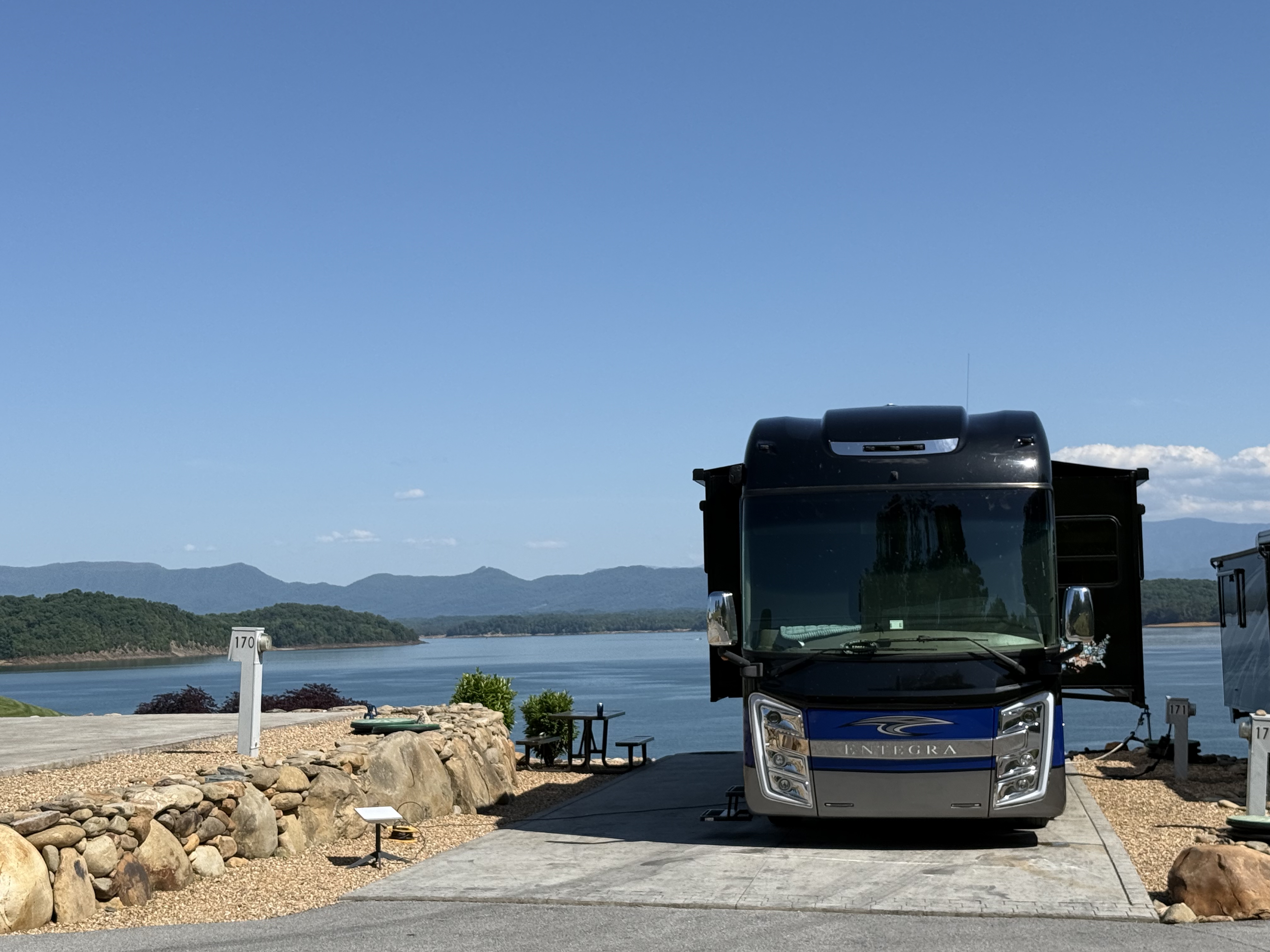 Front of 2021 Entegra Motorhome at Anchor Down RV Resort with Douglas Lake and Smokey Mountains in distance