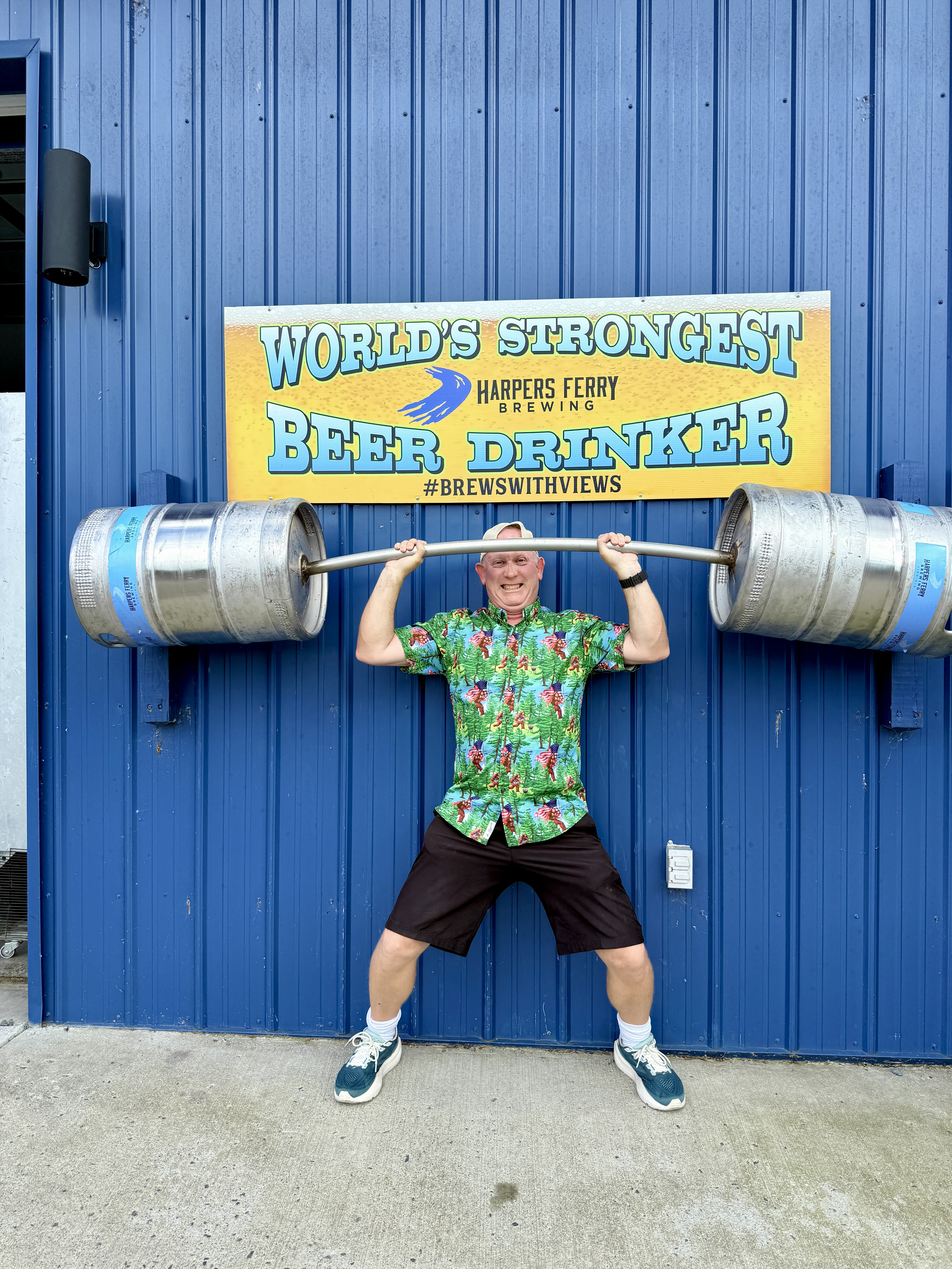 Chad lifting two kegs over his head in the strongest beer drinker in the World exhibit at Harpers Ferry Brewing